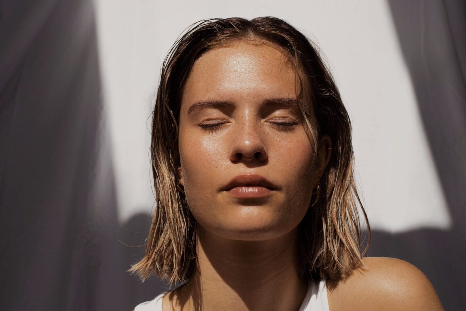 A woman with her eyes closed and head tilted back.