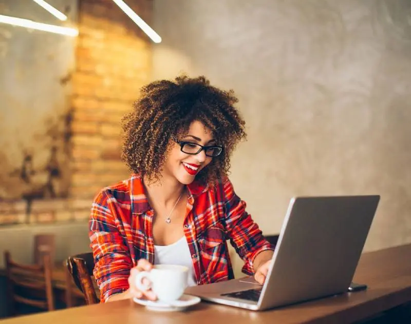 A woman sitting at a table with a laptop.