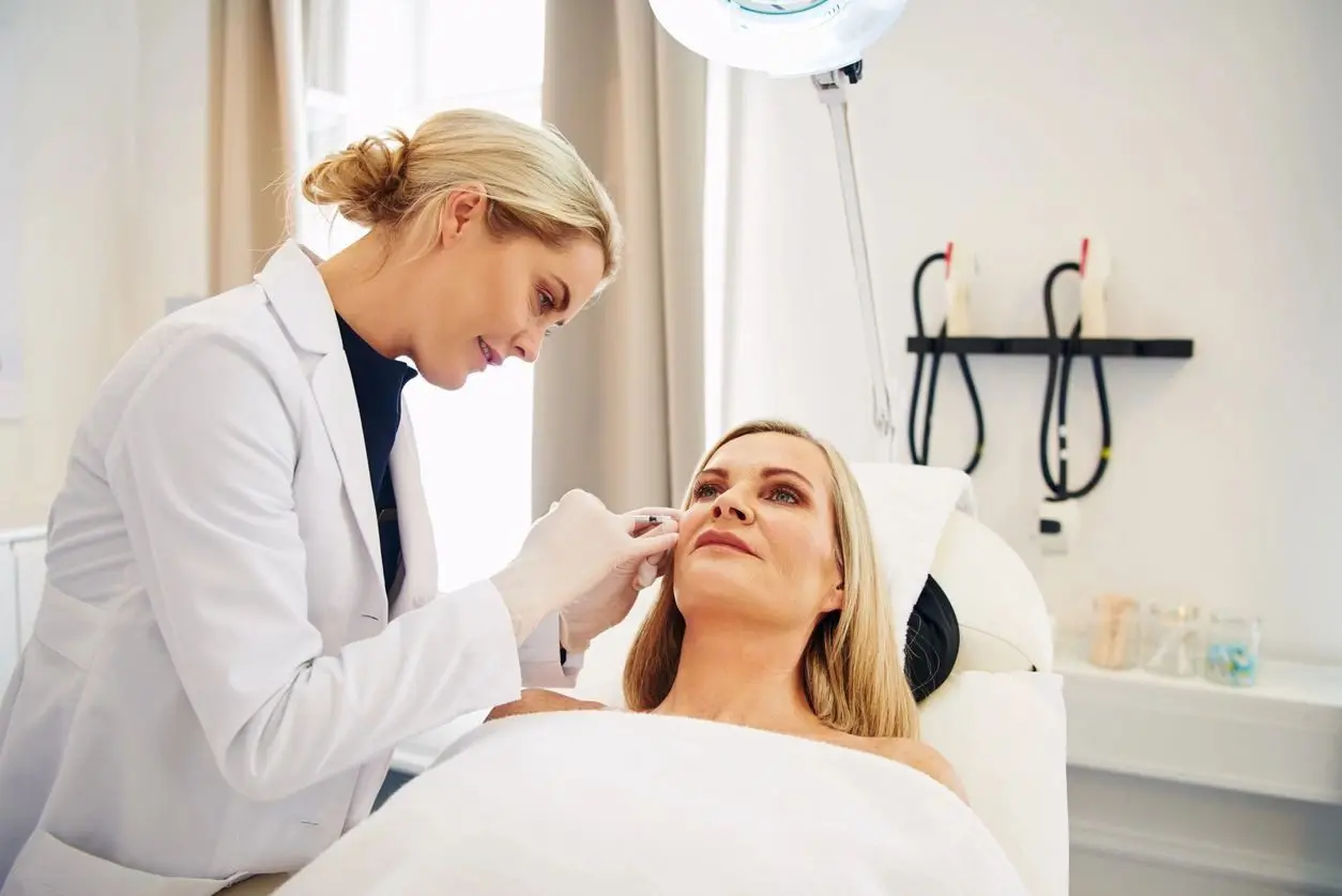 A woman is getting her nose hair done by a doctor.