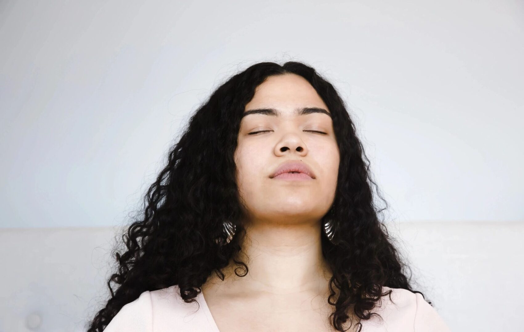 A woman with her eyes closed and hands in the air.