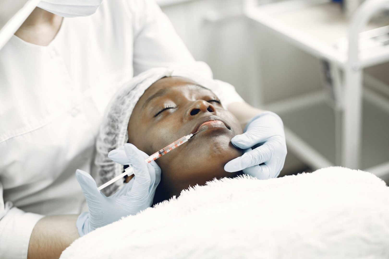 A woman is getting her teeth checked by an esthetician.