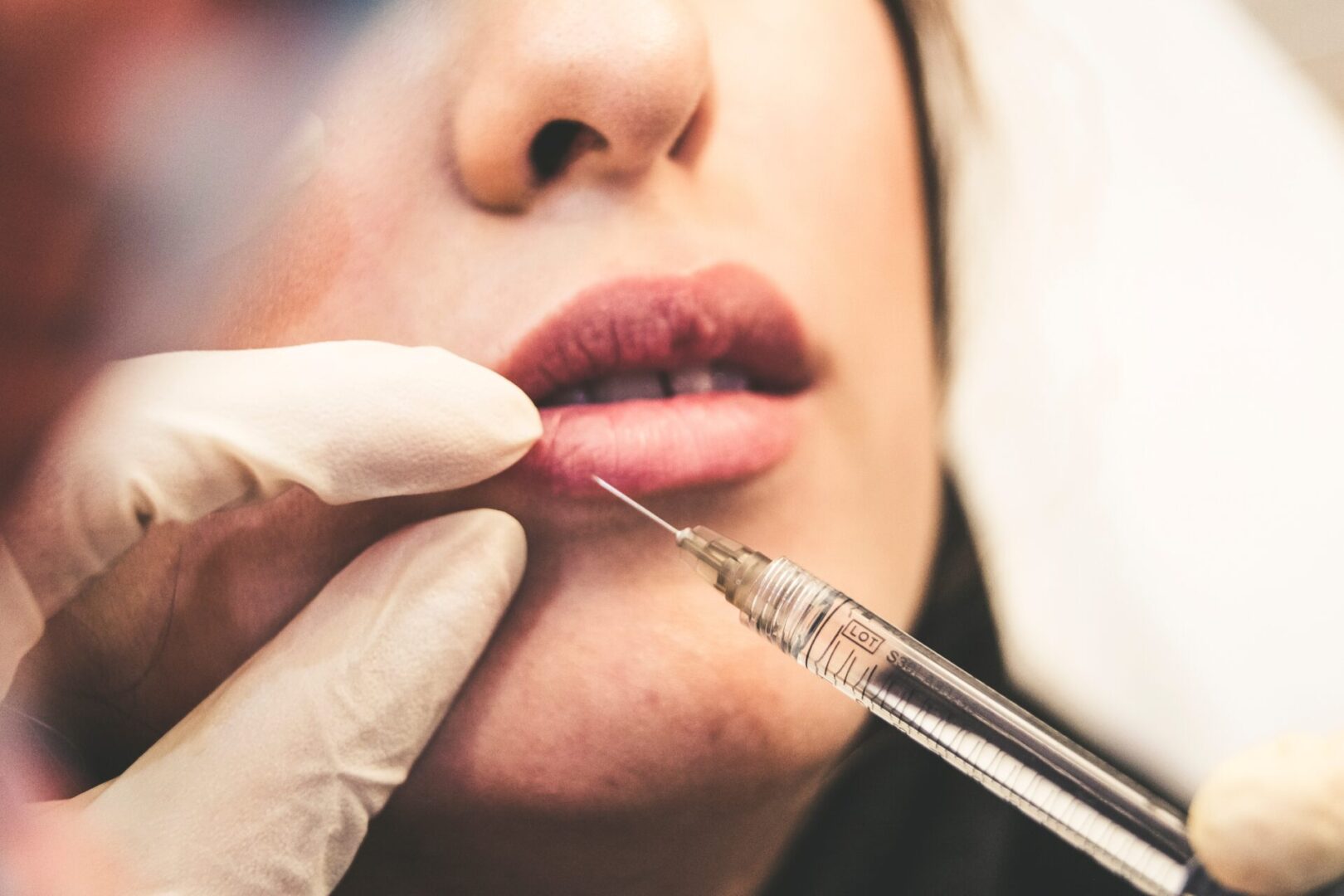 A woman getting her lips waxed by a doctor.